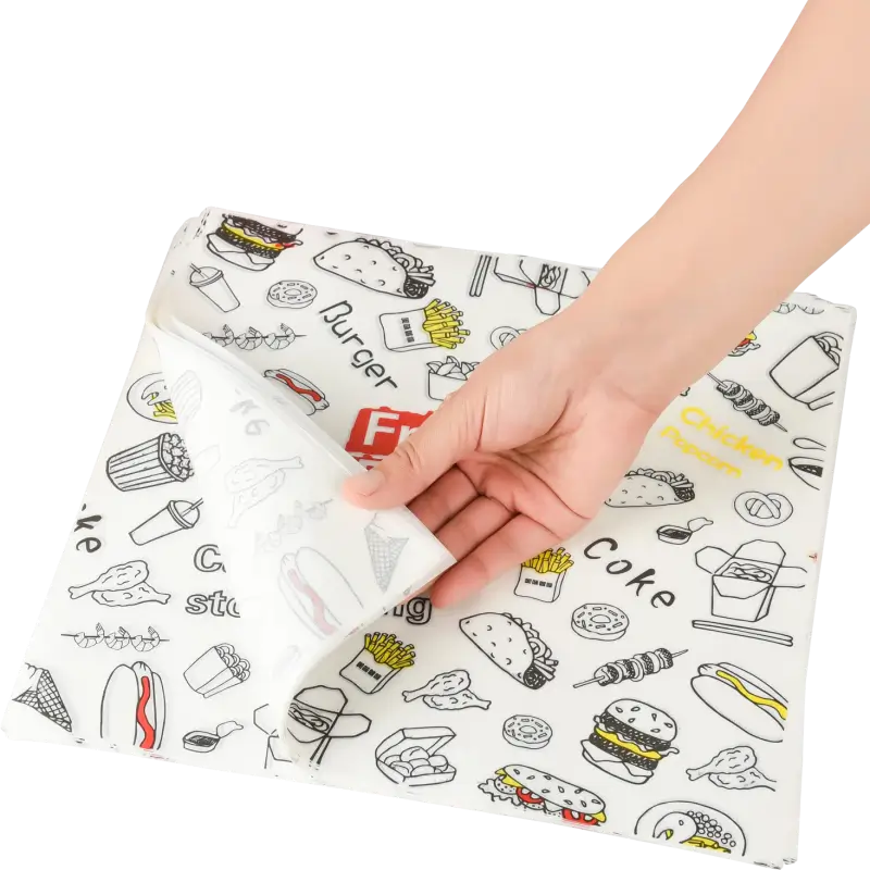 Hand lifting a sheet of custom-printed cheese paper featuring colorful food-themed designs