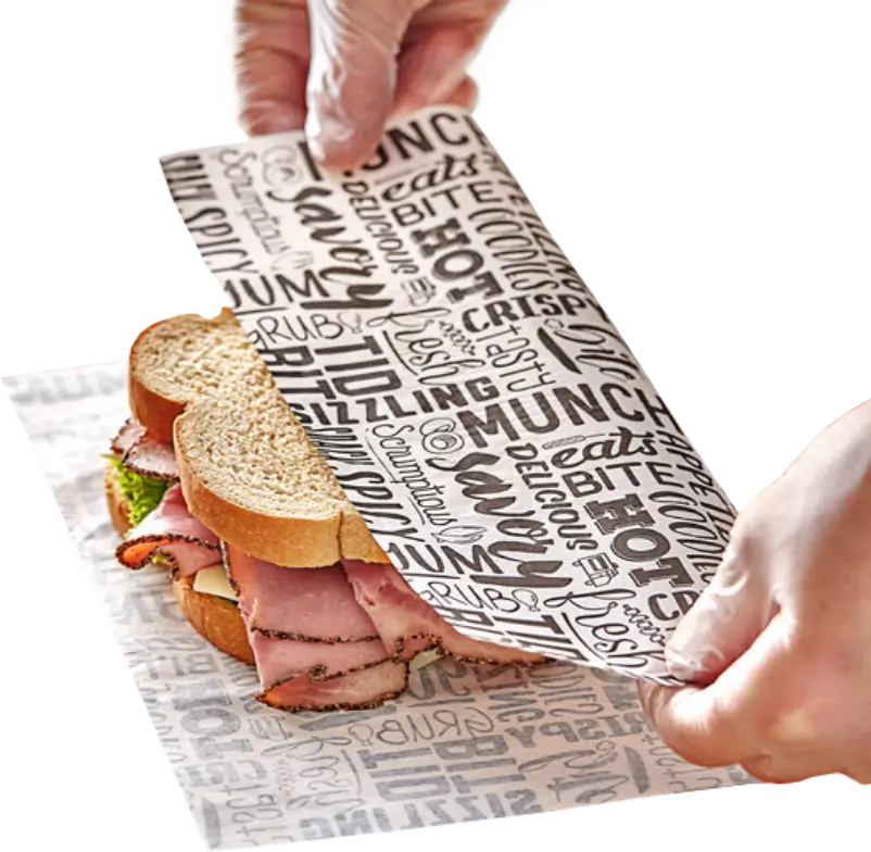 wrapping a deli sandwich with custom-printed deli paper featuring a black text pattern design