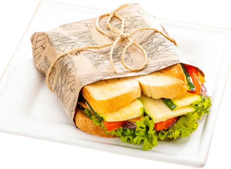 Custom printed sandwich paper wrapped around a sandwich, placed on a plate