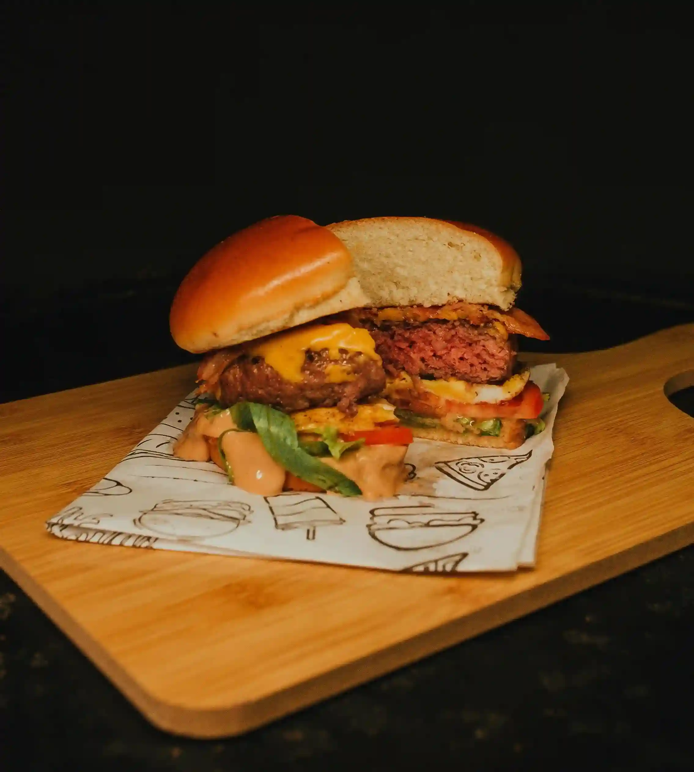 Juicy burger served on eco-friendly custom greaseproof paper, placed on a bamboo table