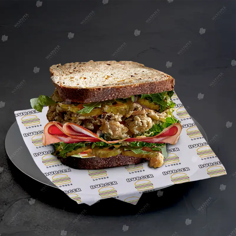 Sandwich stacked with fresh ingredients, lined with custom printed deli paper with burger logo for branding