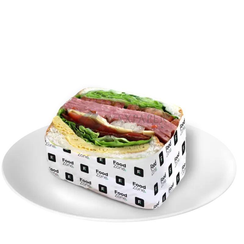 Sandwich with ham, lettuce, and cheese wrapped in custom printed sandwich paper with Food Zone logo
